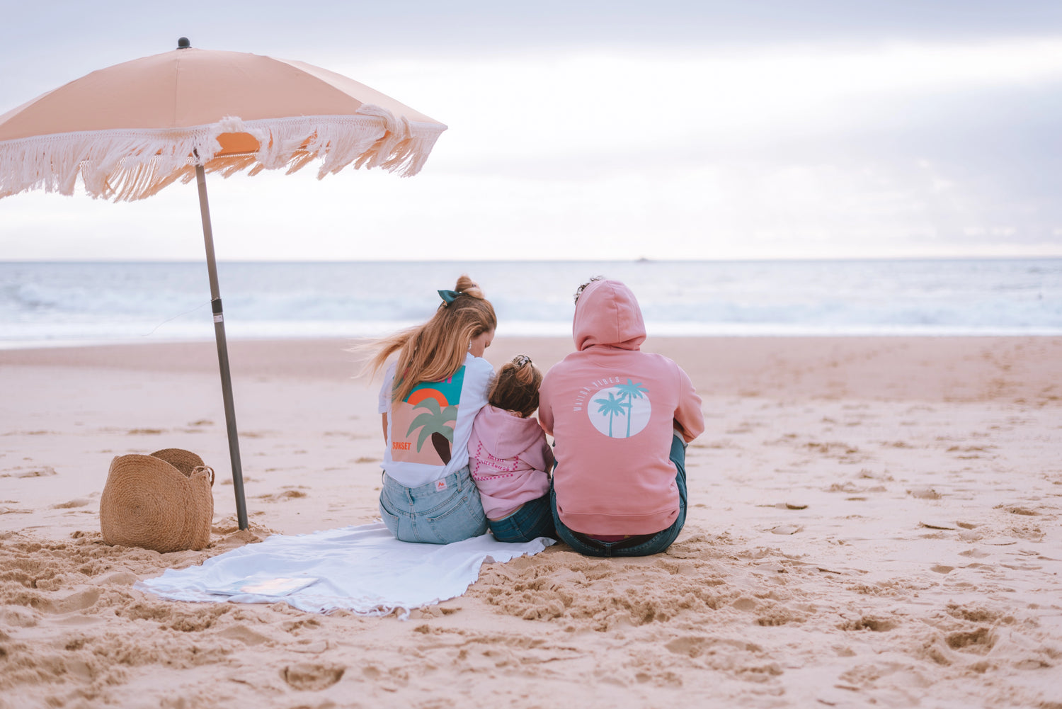 Une famille assise en bord de mer habillé en Waïloa