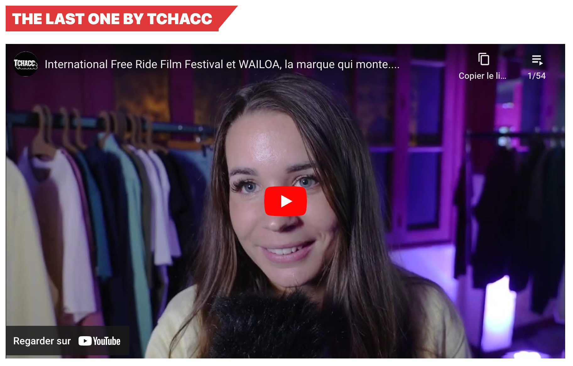 Capture d'écran d'une interview YouTube sur la marque Waïloa lors de l'International Free Ride Film Festival, avec une jeune femme souriante devant un portant de vêtements colorés sous des lumières violettes